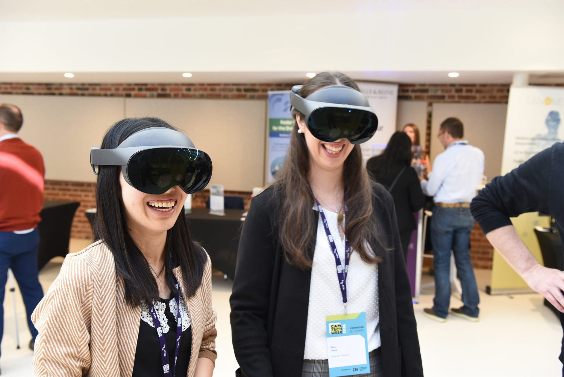 Two smiling, female delegates wearing VR headsets at Cam Tech Week